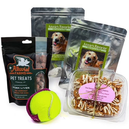 Assorted dog treats including Alluvial Farms, Annie's Favorite Wild Salmon, and The Dining Dog Cafe. with a tennis ball on a white background. | Dog Lover Gift Basket | Made In Washington | Local Gifts For Dog Lovers | Dog Treats Made In the USA