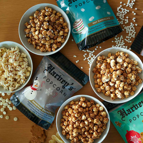 Four bags of Harveys Popcorn with different flavors on a white background | Harvey's Popcorn Holiday Gift Pack | Made In Washington | Christmas Popcorn | Holiday Flavors