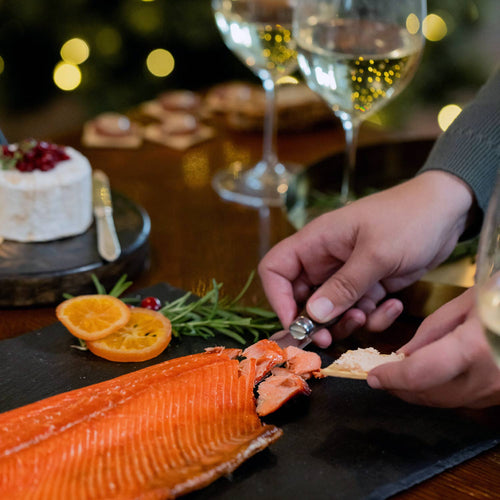 Smoked Salmon on a black slate with decorative elements and 'Copper River' label. | SeaBear Smokehouse Copper River Salmon Fillet | Made In Washington  | Holiday Salmon Gifts