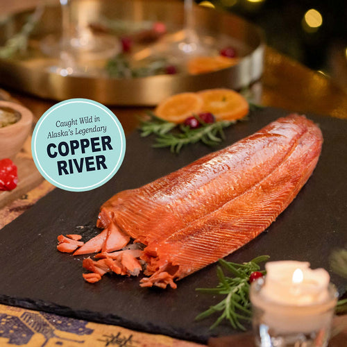 Smoked Salmon on a black slate with decorative elements and 'Copper River' label. | SeaBear Smokehouse Copper River Salmon Fillet | Made In Washington  | Holiday Salmon Gifts