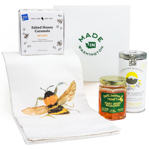 Collection of honey products including a box of salted honey caramels, a jar of honey, and a towel with a bee design. | Tea and Honey Gift Basket | Made In Washington | Local  Gifts For Teatime | Tea & Honey Gift For Tea Lovers