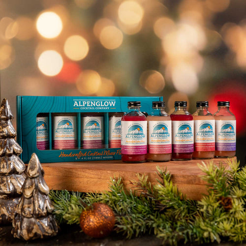 Alpenglow cocktail mix bottles in a wooden gift box with a festive background  | Alpenglow Cocktail Mixers Sampler Gift Set | Made In Washington | Home Bartending