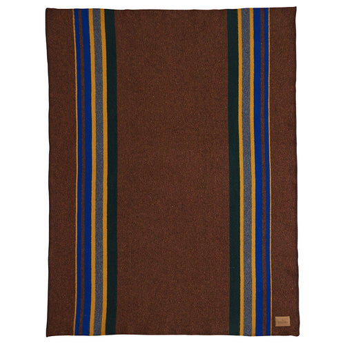 Folded blanket with striped pattern and Pendleton label on a white background | Pendleton Yakima Throw Camp Stripe Tobacco | Made In Washington | PNW Gifts