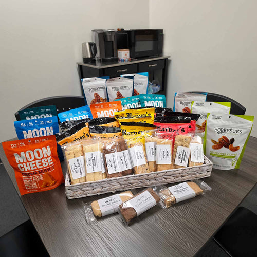 Assorted snack packages including cookies and chips in a basket on a table.