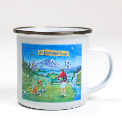 Enamel mug with 'The Beautiful Game' design featuring a soccer player and dog on a scenic background.