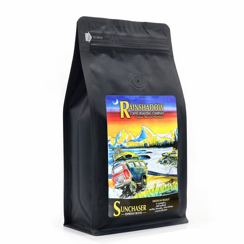 Sunchaser Espresso Blend Black coffee bag with colorful label featuring a scenic design and 'Rainshadow Coffee Roasting Company' branding.