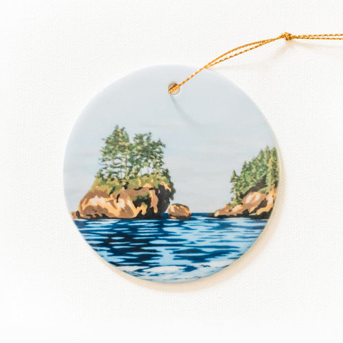 Skies Are Blue porcelain ornament by Port Angeles artist Amy Duffy, featuring a coastal sea stack painting.