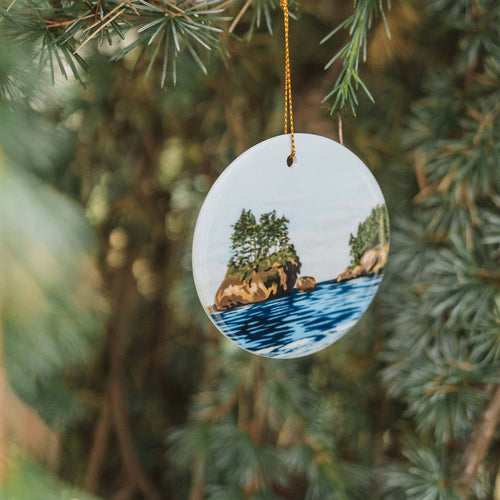 Skies Are Blue porcelain ornament by Port Angeles artist Amy Duffy, featuring a coastal sea stack painting.