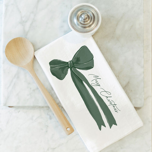 A white towel with a green bow and the words Merry Christmas  on a white background.
