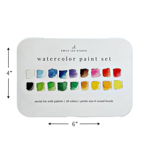 An Emily Lex Studio watercolor paint set in a white metal tin, shown open with 18 color pans, a wooden-handled brush, and a color chart sheet inside the lid on a white background.