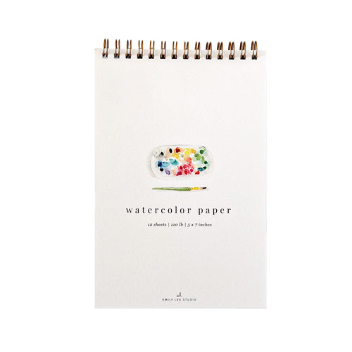 A white spiral-bound watercolor paper pad with a small paint palette and paintbrush illustration on the cover, labeled 'watercolor paper' and '12 sheets | 120 lb | 5 x 7 inches'.