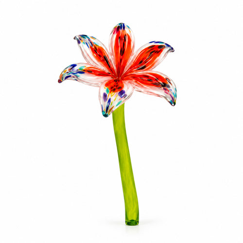 Low angle view of an orange speckled hand-blown glass lily flower on a green stem.