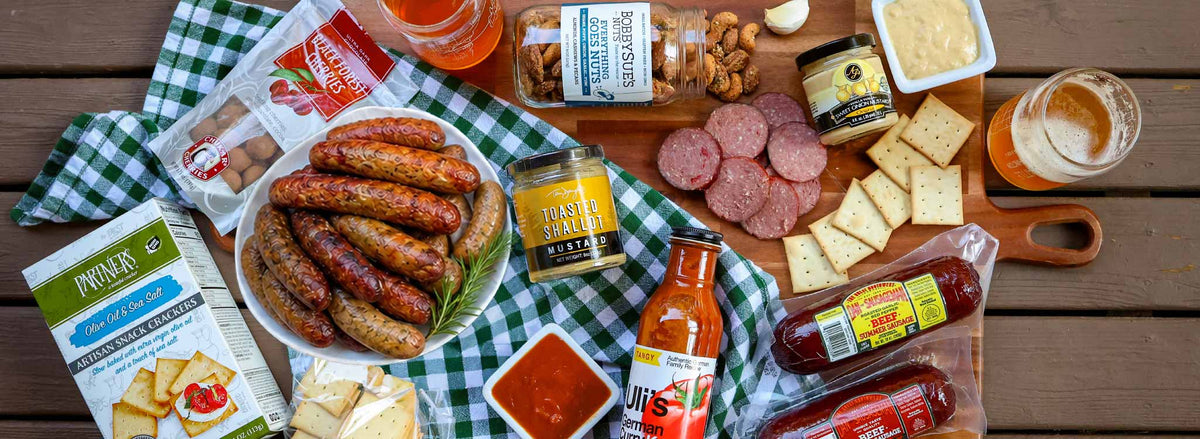 Shop Oktoberfest food gifts featuring local sausages, German curry ketchup, mustards and tall can beer glasses.